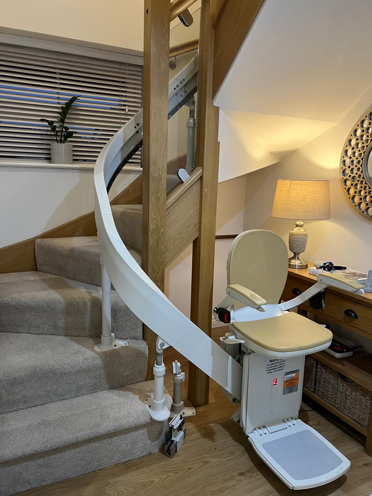 Curved stairlift installed on a winding staircase